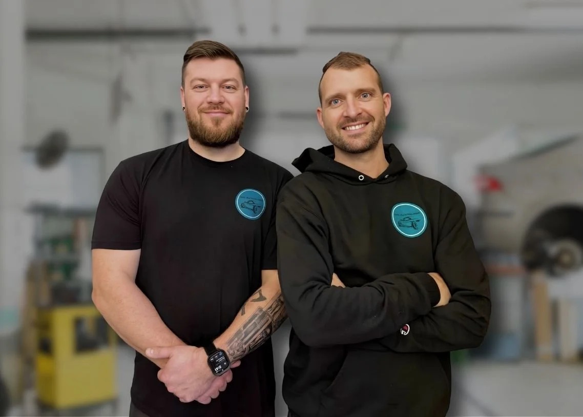 Two auto glass technicians standing in a workshop